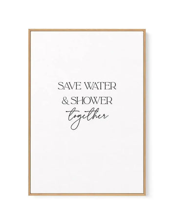 Framed canvas art print with natural wood frame displaying text reading "SAVE WATER & SHOWER together" in black lettering. The first two words appear in sans-serif capitals, while "together" is written in flowing black script. White background with minimalist design. Wood frame has a warm tan finish.