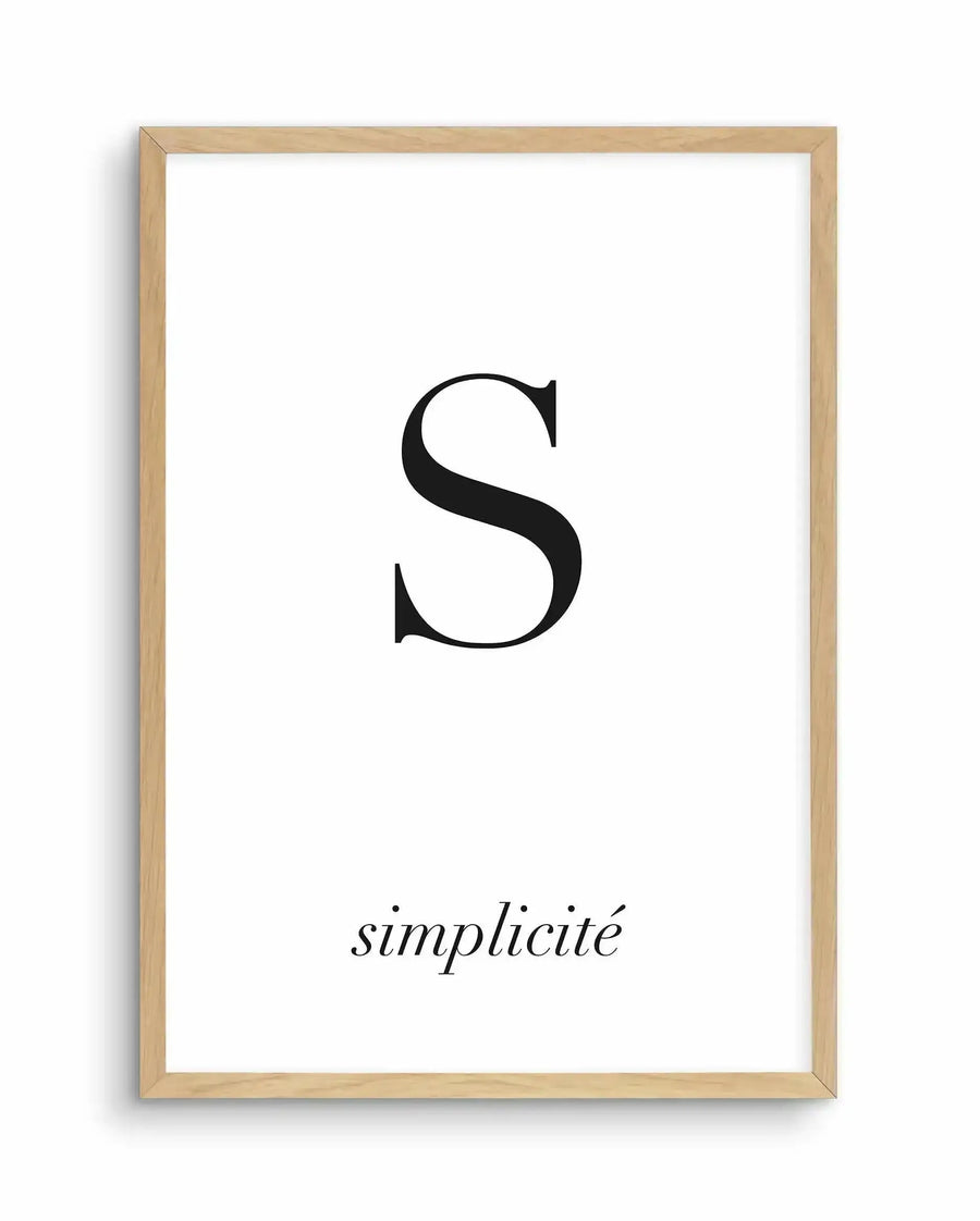 Simplicity art print displayed in a natural wood frame with white border. The design features a large black serif letter "S" centered on a white background, with the word "simplicité" in small italic text below it. Minimalist composition with clean typography and ample white space.