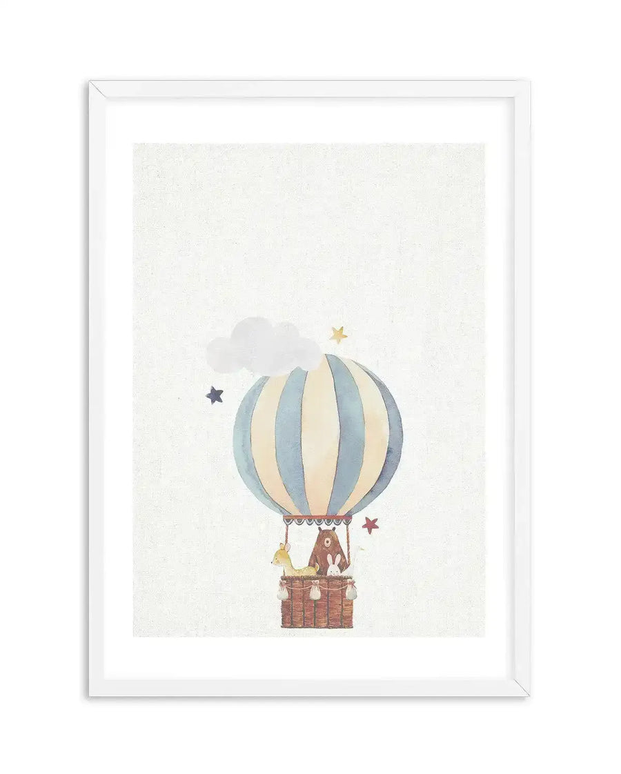 Watercolour art print featuring a hot air balloon in pale blue and cream stripes, carrying a brown bear, a fawn, and a white rabbit in a woven basket. The balloon floats against a textured white background with a fluffy white cloud and scattered gold and blue stars, displayed in a white frame with a white border.