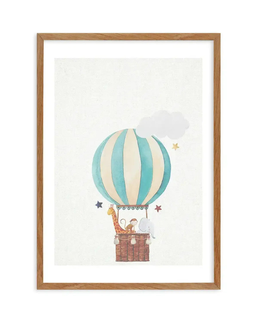 Watercolour art print featuring a hot air balloon with vertical stripes in pale blue and cream, floating against a textured white background. The basket of the balloon holds a giraffe, a monkey, and an elephant. Small stars in blue, red, and yellow are scattered around the balloon, and a white cloud is visible above it. The print is displayed in a natural oak frame with a white border.