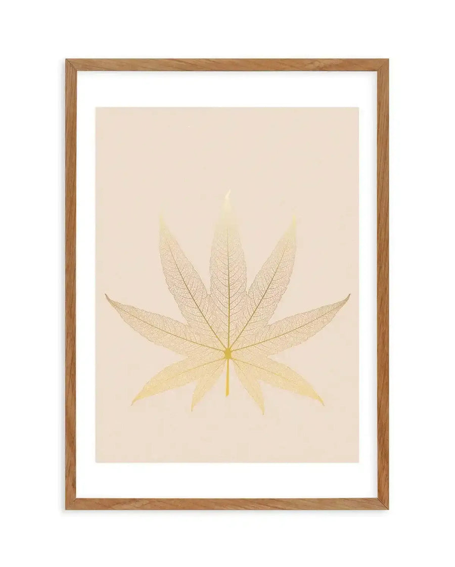 Art print featuring a detailed skeletal leaf in a warm golden-yellow hue, showcasing intricate vein patterns against a soft cream background, displayed in a natural oak frame with white border.