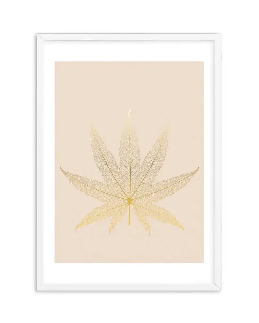 Framed art print featuring a delicate, translucent skeleton leaf with seven pointed lobes, resembling a maple or cannabis leaf, in shades of pale gold and cream against a soft, blush pink background, displayed in a white frame with white border.