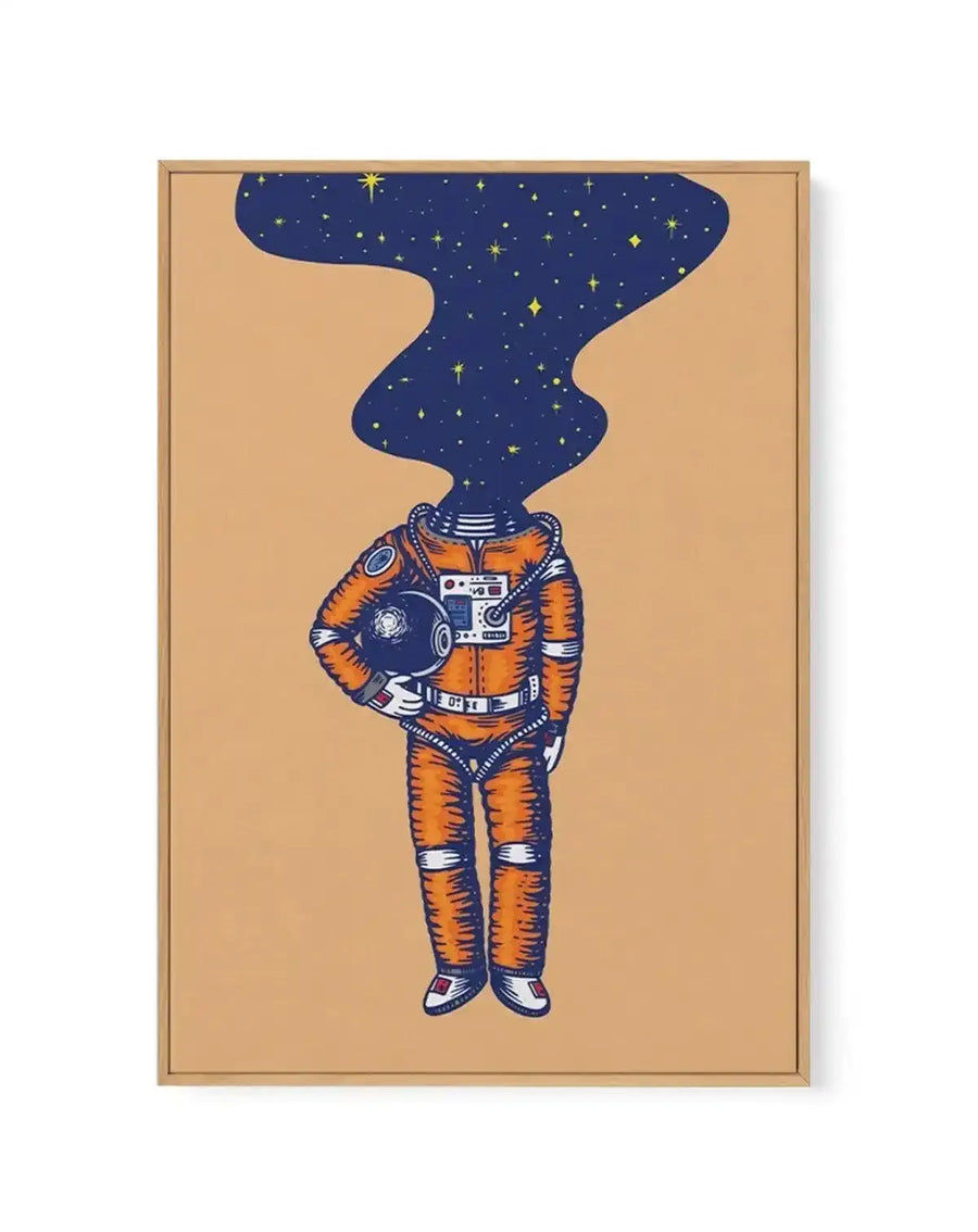 Framed canvas art print featuring an illustration of an astronaut in an orange and white spacesuit holding a helmet, set against a tan background. The astronaut's head is replaced by a dark navy starfield filled with golden and white stars. The artwork is displayed in a natural wood frame with a white border.