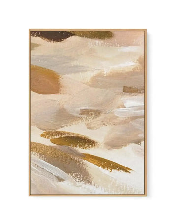 Abstract canvas print featuring broad, sweeping brushstrokes in warm, earthy tones of beige, cream, and muted brown, with accents of shimmering gold and subtle grey. The composition has a dynamic, layered quality with visible paint texture, displayed in a natural wood frame.