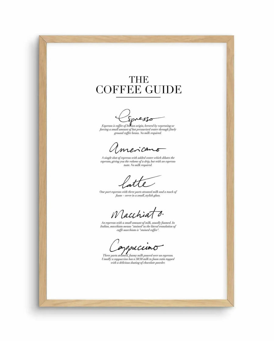 Art print featuring a coffee guide with five popular coffee types: Espresso, Americano, Latte, Macchiato, and Cappuccino. Each coffee type is written in a elegant, flowing script with a short description in a classic serif font below. The text is black on a clean white background, displayed in a natural oak frame with a white border.