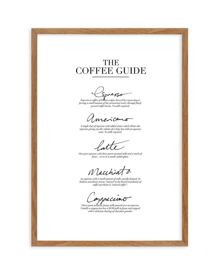 Framed art print with a white background and black text, displayed in a natural oak frame with white border. The print features "THE COFFEE GUIDE" in bold, sans-serif font at the top, followed by five coffee types (Espresso, Americano, Latte, Macchiato, Cappuccino) in elegant script font, each with a short description in a smaller, serif font.