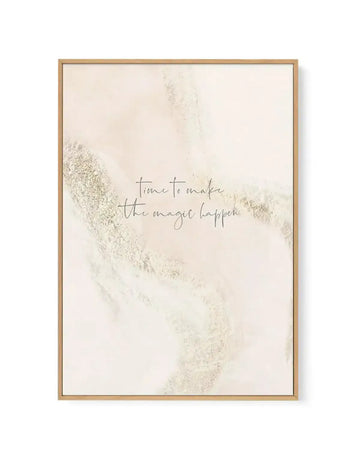 Framed canvas art print featuring the handwritten text "time to make the magic happen" in thin gray script centered on a cream background. Soft, textured brushstroke elements in pale gold and beige create an abstract watercolor effect in the upper left and lower right corners. Natural wood frame with white border. Vertical rectangular composition with minimalist aesthetic and warm, neutral color palette.