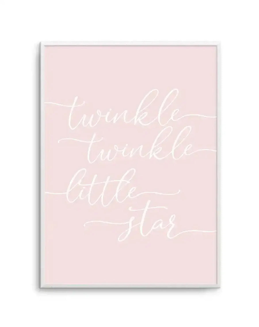 Art print with soft blush pink background featuring white handwritten calligraphy text reading "twinkle twinkle little star" arranged in three lines with flowing decorative flourishes. Displayed in a simple light grey frame with white border. Minimalist design with gentle, whimsical aesthetic suitable for nursery or child's room decor.