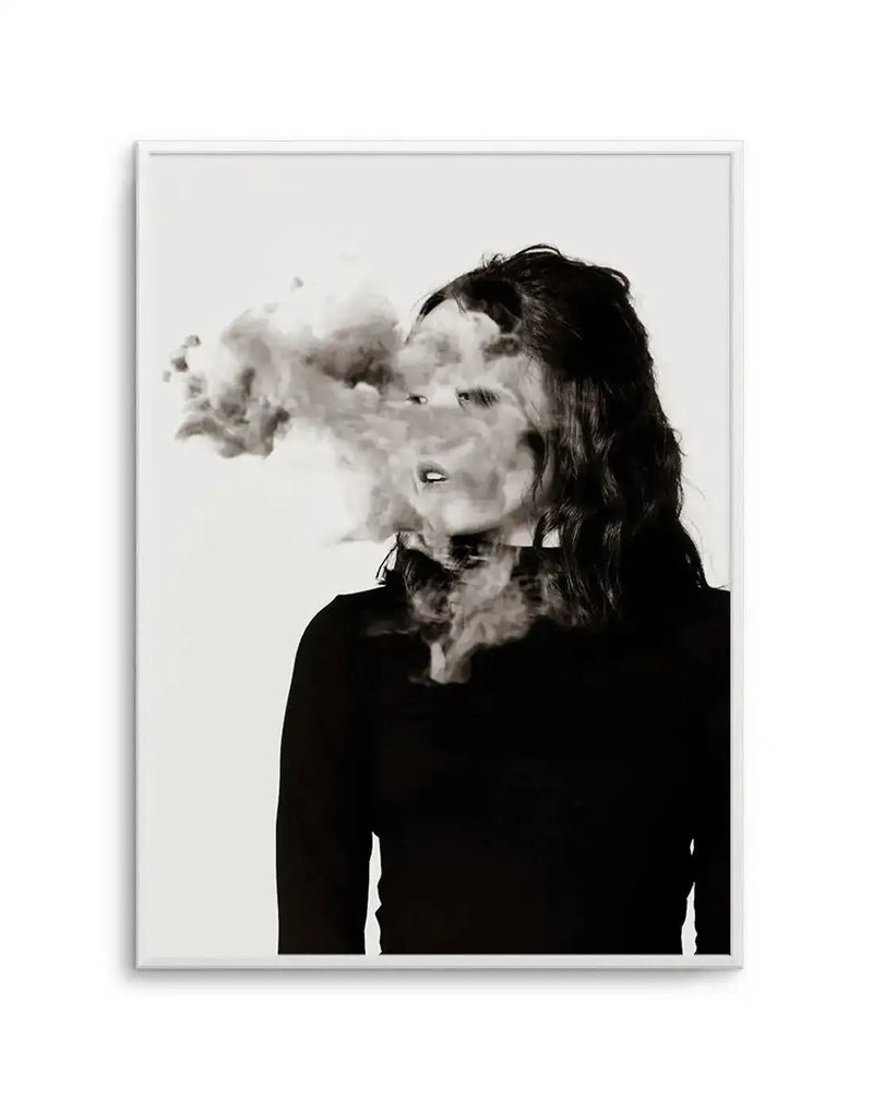 Framed black and white photography art print featuring a woman's profile with her face partially obscured by a cloud of smoke. The woman has dark, wavy hair and is wearing a dark, long-sleeved top. The smoke emanates from her mouth and neck area, creating a surreal and mysterious effect against a plain white background.