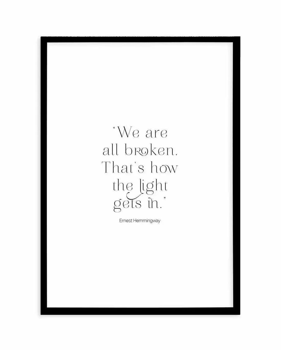 "Text art print featuring the quote 'We are all broken. That's how the light gets in.' by Ernest Hemingway, in a delicate serif font on a clean white background, displayed in a black frame with white border."