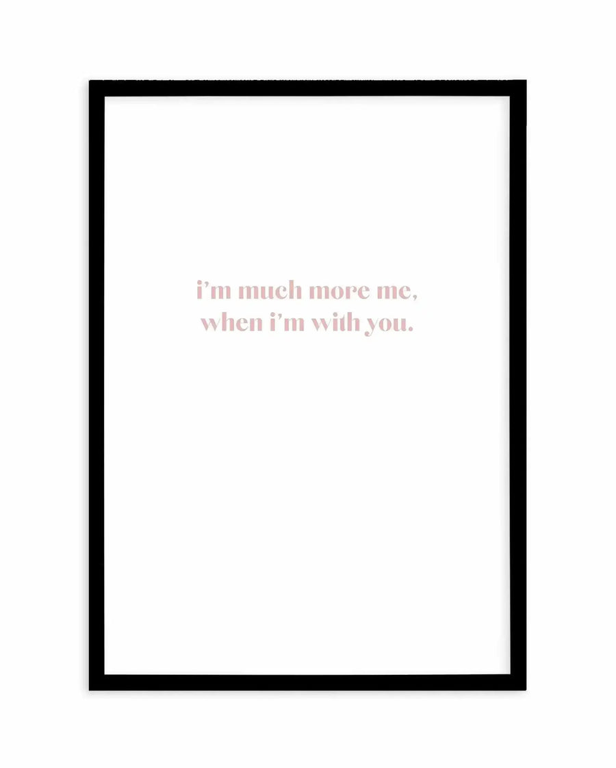 Art print with black frame displaying centered text in dusty rose pink that reads "i'm much more me, when i'm with you." on a white background. Simple, minimalist design with serif typography positioned in the upper-center portion of the print.