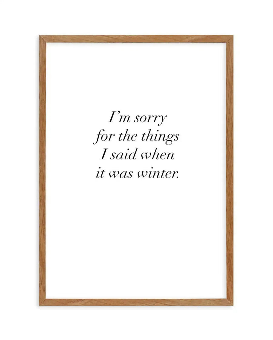 Art print featuring the quote "I'm sorry for the things I said when it was winter." in a delicate serif font, printed on fine art paper and displayed in a natural oak frame with white border.