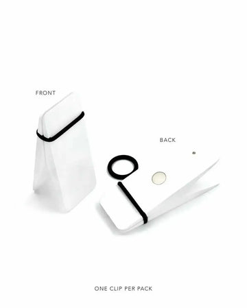 Minimalist product display showing a white paper bag with black handle against a white background, labeled "FRONT." To the right, the "BACK" view displays the same bag opened flat, alongside its components: a black elastic clip, a black rubber band, and a small circular adhesive dot. Text at bottom reads "ONE CLIP PER PACK." The image uses clean photography with soft shadows to show the bag's structure, materials, and included accessories in a simple, organized layout.