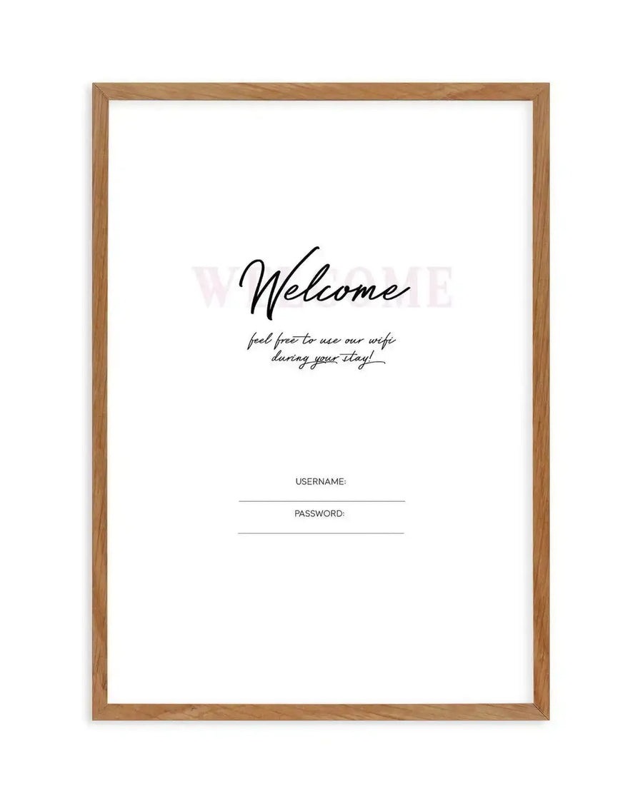 Art print in natural wood frame featuring handwritten-style text reading "Welcome" in black script, followed by smaller cursive text stating "feel free to use our wifi during your stay!" Below are two blank lines labeled "USERNAME:" and "PASSWORD:" in simple sans-serif font. The design is printed on white background with minimalist aesthetic and warm wood frame with visible grain texture.