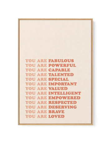 Framed canvas print featuring a list of positive affirmations in a retro-inspired font with a gradient of warm peach to coral red on a cream background, displayed in a natural oak frame with white border. The text reads: "YOU ARE FABULOUS, YOU ARE POWERFUL, YOU ARE CAPABLE, YOU ARE TALENTED, YOU ARE SPECIAL, YOU ARE IMPORTANT, YOU ARE VALUED, YOU ARE INTELLIGENT, YOU ARE EMPOWERED, YOU ARE RESPECTED, YOU ARE DESERVING, YOU ARE BRAVE, YOU ARE LOVED."
