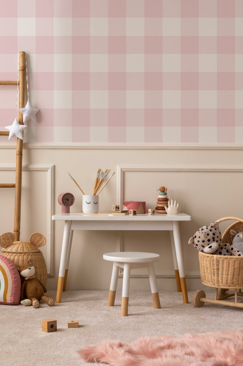 Pink gingham check wallpaper installed in child's room with white desk, toys, wicker basket and beige carpet